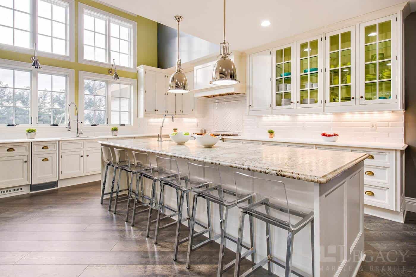 Modern granite countertop kitchen with sleek cabinetry, chairs and pendant lighting
