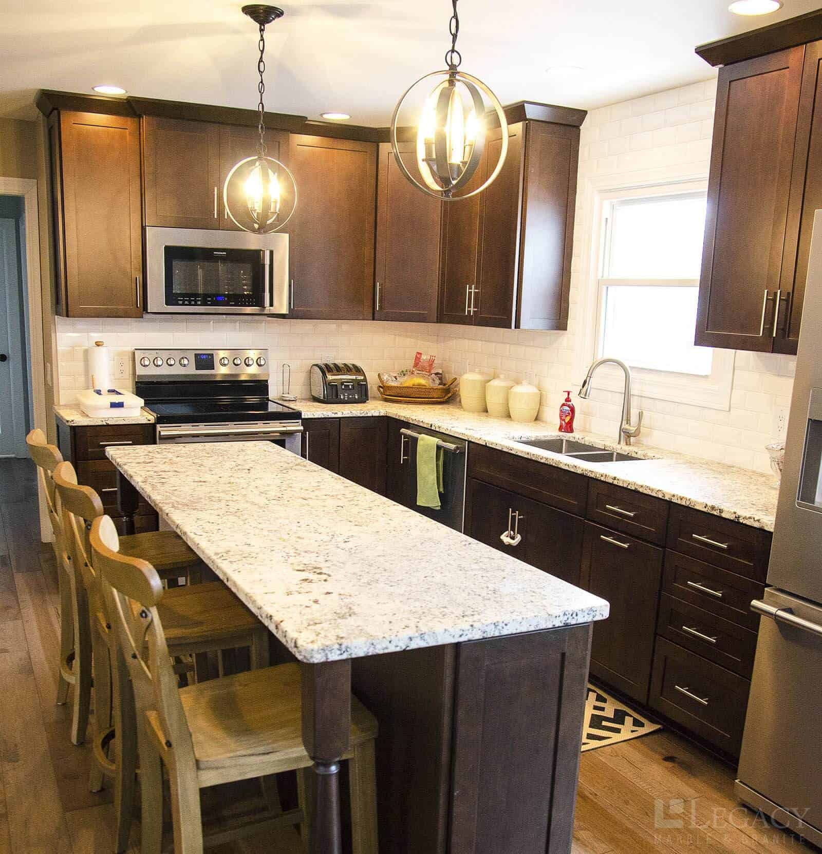 Granite kitchen island with bar stools and modern pendant lighting
